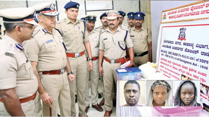 Indian police officers in khaki uniforms gather around a display board and a table with mugshots of suspects.